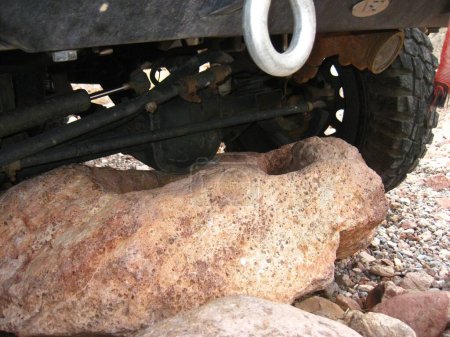 Téléchargez les photos : Jeep Wrangler with Big Tires Stuck on Boulder. High quality photo - en image libre de droit