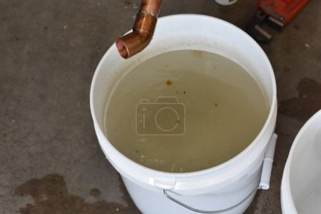 Foto de Cubo sucio de agua soldando una tubería de cobre. Foto de alta calidad - Imagen libre de derechos