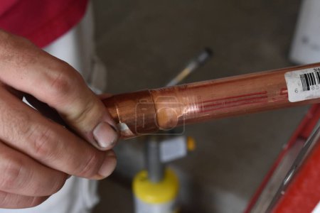 Foto de Manos soldando tubos de cobre juntos en el garaje. Foto de alta calidad - Imagen libre de derechos