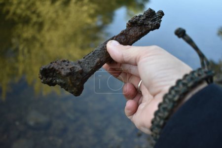 Photo for Fingers Holding Old Rusty and Crusty Railroad Tie by River by Fox River Burlington, Wisconsin . High quality photo - Royalty Free Image