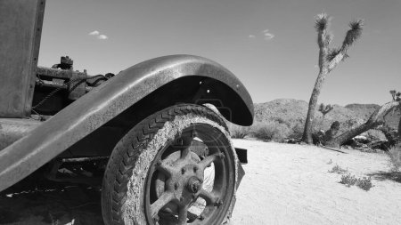 Aile avant et pneu d'une vieille voiture rouillée abandonnés près de Wall Street Mill dans le parc national Joshua Tree, noir et blanc. Photo de haute qualité