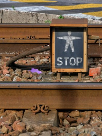 Foto de Indicador de cruce iluminado sin peatones, cerca de las vías del ferrocarril. - Imagen libre de derechos