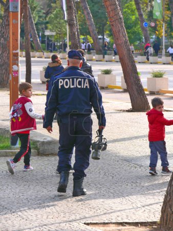 Foto de Policía con una máscara de gas en la mano, caminando por las calles de Tirana - Imagen libre de derechos