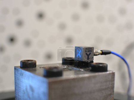 Photo for Triaxial accelerometer stuck on steel cube, screwed on an electrodynamic shaker. - Royalty Free Image