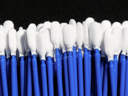 Foto de Hisopos orales de un laboratorio de análisis médico en un fondo negro. El palo de retención es azul. - Imagen libre de derechos