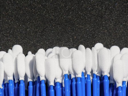 Foto de Hisopos orales de un laboratorio de análisis médico en un fondo negro. El palo de retención es azul. - Imagen libre de derechos