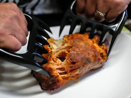 Photo for Shredding of pork roast (with claws), in preparation for pulled pork - Royalty Free Image