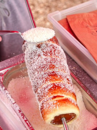 Téléchargez les photos : Préparation d'un kurtoskalacs (gâteau à la broche hongrois de Transylvanie) dans un étal de marché. - en image libre de droit