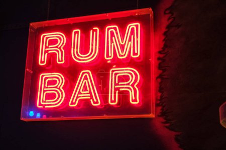 Photo for Illuminated red sign with the inscription RUM BAR, in a cosy, dark atmosphere. - Royalty Free Image
