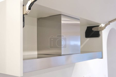 Side view of a cooker hood integrated into a kitchen cabinet