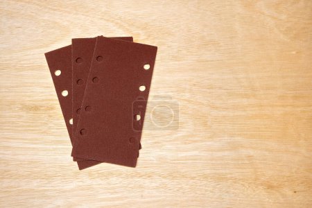 Photo for Sanding paper for vibrating sander, on wood panel. - Royalty Free Image