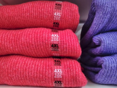 Wool pullovers, size 4XL, stacked on a display rack