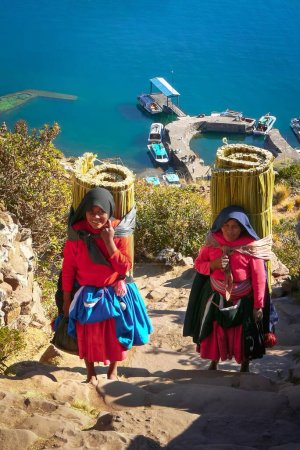 Téléchargez les photos : Femmes portant une lourde charge de roseaux, Taquile île Pérou Amérique du Sud - en image libre de droit