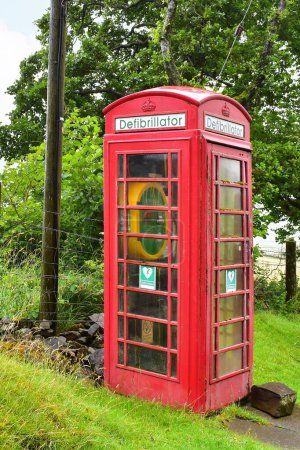 Foto de Típica cabina de teléfono roja británica reutilizada como estación de desfibrilador, Escocia rural, Reino Unido, Europa - Imagen libre de derechos