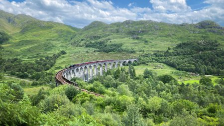 Téléchargez les photos : Train à vapeur Jacobite Express de renommée mondiale (alias Hogwarts Express) traversant le chemin de fer Glenfinnan Viaduct dans un magnifique paysage montagneux, Écosse, Royaume-Uni, Europe - en image libre de droit