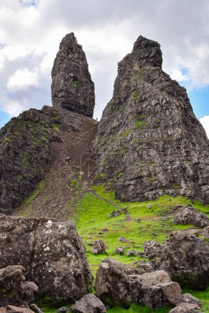 Téléchargez les photos : Man feeling small standing among the huge Old Man of Storr rock formations, Isle of Skye, Écosse point de repère, Royaume-Uni, Voyage Europe. - en image libre de droit