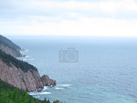 a beautiful view of the sea coast with the waves and a cloudy sky