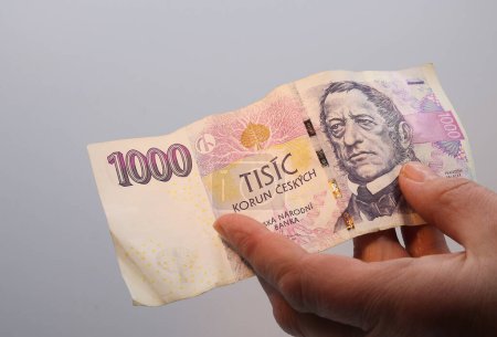 Eine Banknote von tausend tschechischen Kronen in der Hand einer Frau