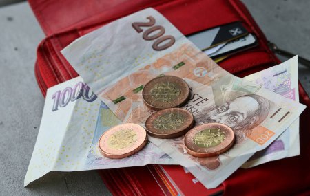 Geld in roter Brieftasche, tschechische Kronen, Banknoten und Münzen