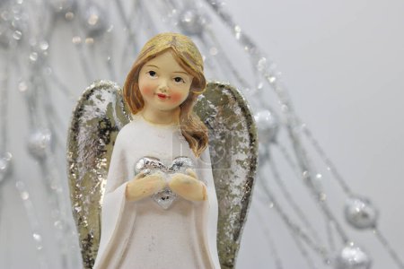 Christmas card with an angel holding a heart in his hand-stock-photo