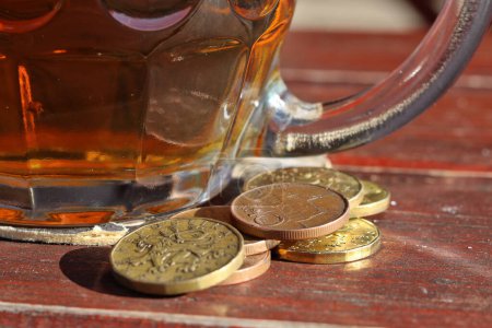 Großaufnahme von Münzen - Tschechische Kronen, platziert neben einem Pint Bier - Geld bereit, für Bier bezahlt zu werden