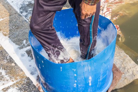 Téléchargez les photos : Hazratbal, Srinagar, Jammu-et-Cachemire, Inde. Homme lavant la lessive sur la rive du lac Dal. - en image libre de droit