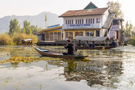 Téléchargez les photos : Rainawari, Srinagar, Jammu-et-Cachemire, Inde. 24 octobre 2022. Homme pagayant sur un bateau traditionnel Shikara au lac Dal. - en image libre de droit