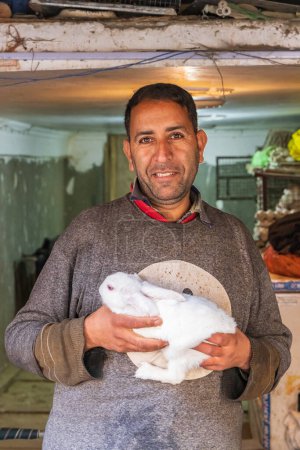 Téléchargez les photos : Bohri Kadal, Srinagar, Jammu-et-Cachemire, Inde. 25 octobre 2022. Gardien de magasin tenant lapin à vendre à Srinagar. - en image libre de droit