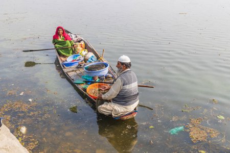 Téléchargez les photos : Rainawari, Srinagar, Jammu-et-Cachemire, Inde. 28 octobre 2022. Homme et femme vendant du poisson d'un bateau traditionnel au lac Dal. - en image libre de droit