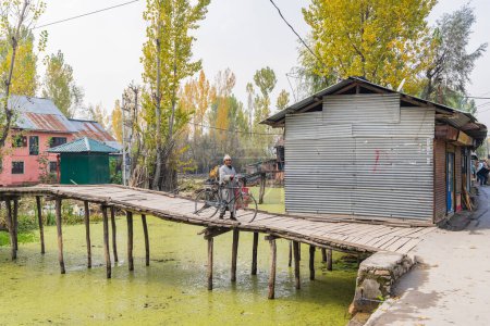 Téléchargez les photos : Rainawari, Srinagar, Jammu-et-Cachemire, Inde. 1er novembre 2022. Homme sur une passerelle au-dessus d'un canal au lac Dal. - en image libre de droit