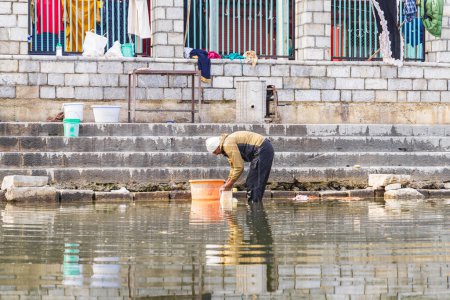 Téléchargez les photos : Srinagar, Jammu-et-Cachemire, Inde. 1er novembre 2022. Homme faisant la lessive le long de la rive du lac Dal. - en image libre de droit