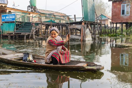 Téléchargez les photos : Rainawari, Srinagar, Jammu-et-Cachemire, Inde. Le 2 novembre 2022. Femme pagayant sur un bateau traditionnel sur le lac Dal. - en image libre de droit