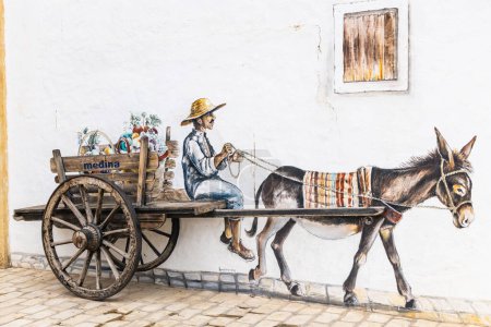 Téléchargez les photos : Yasmine Hammamet, Nabeul, Tunisie. Le 6 mars 2023. Peinture murale d'un homme conduisant un chariot à âne en Tunisie. - en image libre de droit