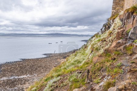 Lindisfarne, Holy Island, Berwick-upon-Tweed, Northumberland, England, Großbritannien. Steiniger Strand unterhalb von Schloss Lindisfarne auf der Heiligen Insel.