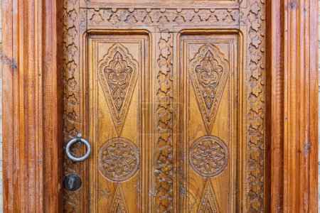 Khiva, région de Xorazm, Ouzbékistan, Asie centrale. Magnifiquement sculpté porte en bois sur une maison à Khiva.