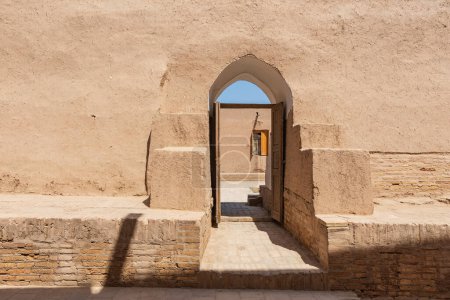 Chiwa, Region Xorazm, Usbekistan, Zentralasien. Tür durch eine Lehmwand in Chiwa.