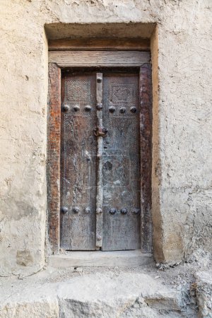 Buchara, Usbekistan, Zentralasien. Eine alte Holztür an einem Lehmbauwerk in Buchara.