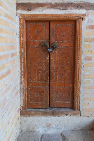 Bukhara, Uzbekistan, Central Asia. Decoratively carved wooden door at the Kalan Mosque in Bukhara.