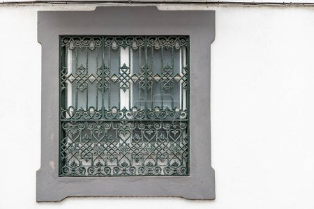 Angra do Heroismo, Terceira, Azores, Portugal. Green barred window in a concrete frame.