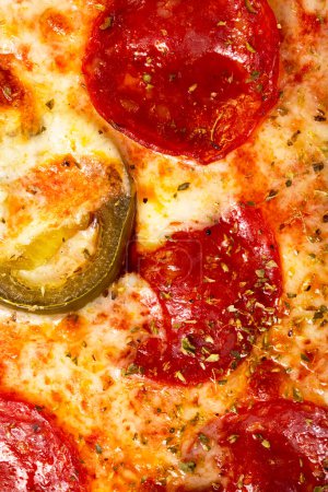 Téléchargez les photos : Salami pepperoni pizza texture avec jalapeno comme fond. Un gros plan d'une pizza. Macro photo. Pizza salami pepperoni aux jalapenos. - en image libre de droit