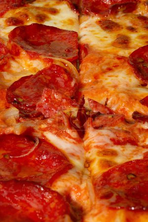 Téléchargez les photos : Salami pepperoni pizza texture avec l'oignon comme fond. Un gros plan d'une pizza. Macro photo. Pizza salami pepperoni à l'oignon. - en image libre de droit