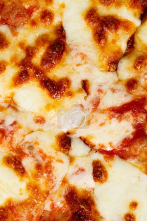 Téléchargez les photos : Pizza avec texture de fromage mozzarella comme fond. Un gros plan d'une pizza. Macro photo. Pizza Margherita. - en image libre de droit