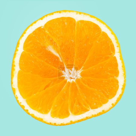 Téléchargez les photos : Une tranche d'orange isolée sur fond bleu. - en image libre de droit