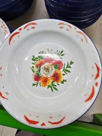 Classic enamel plate featuring a white base with blue rim and vibrant yellow and red floral motifs at the center, adding a touch of timeless elegance.