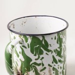 A gleaming cup with white and green patterns, once a symbol of laborers' and farmers' struggles in the 1920s, now used to savor beverages with a vintage classic touch.