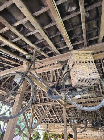Una bicicleta vintage adornada con alforjas de bambú cuelga elegantemente del techo, añadiendo un encanto rústico a la decoración interior.