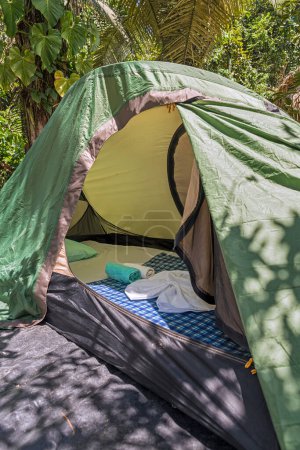 Téléchargez les photos : Vue rapprochée à l'intérieur d'une tente verte avec matelas, coussin, drap et serviettes - en image libre de droit