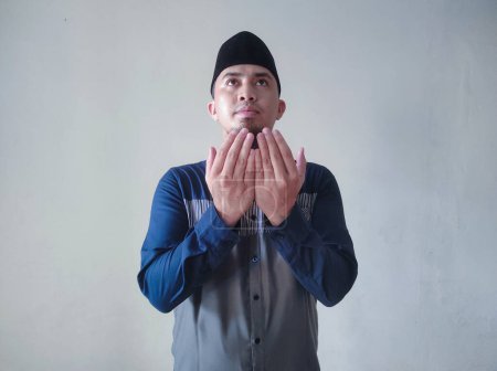 Téléchargez les photos : Asiatique musulman est levant la main dans la prière - en image libre de droit