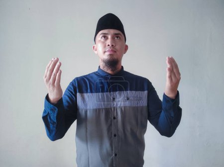 Téléchargez les photos : Asiatique musulman est levant la main dans la prière - en image libre de droit
