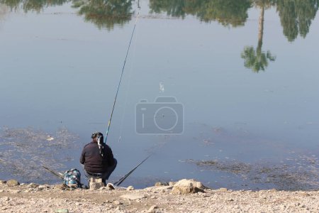 Photo for Back view of a fisher on a river bed - Royalty Free Image